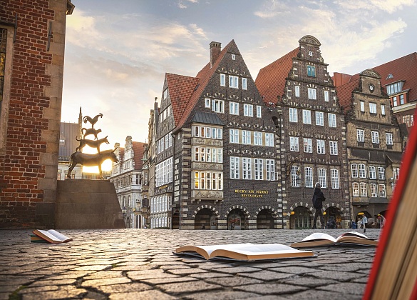 Bremer Stadtmusikanten mit aufgeklappten Büchern auf dem Platz